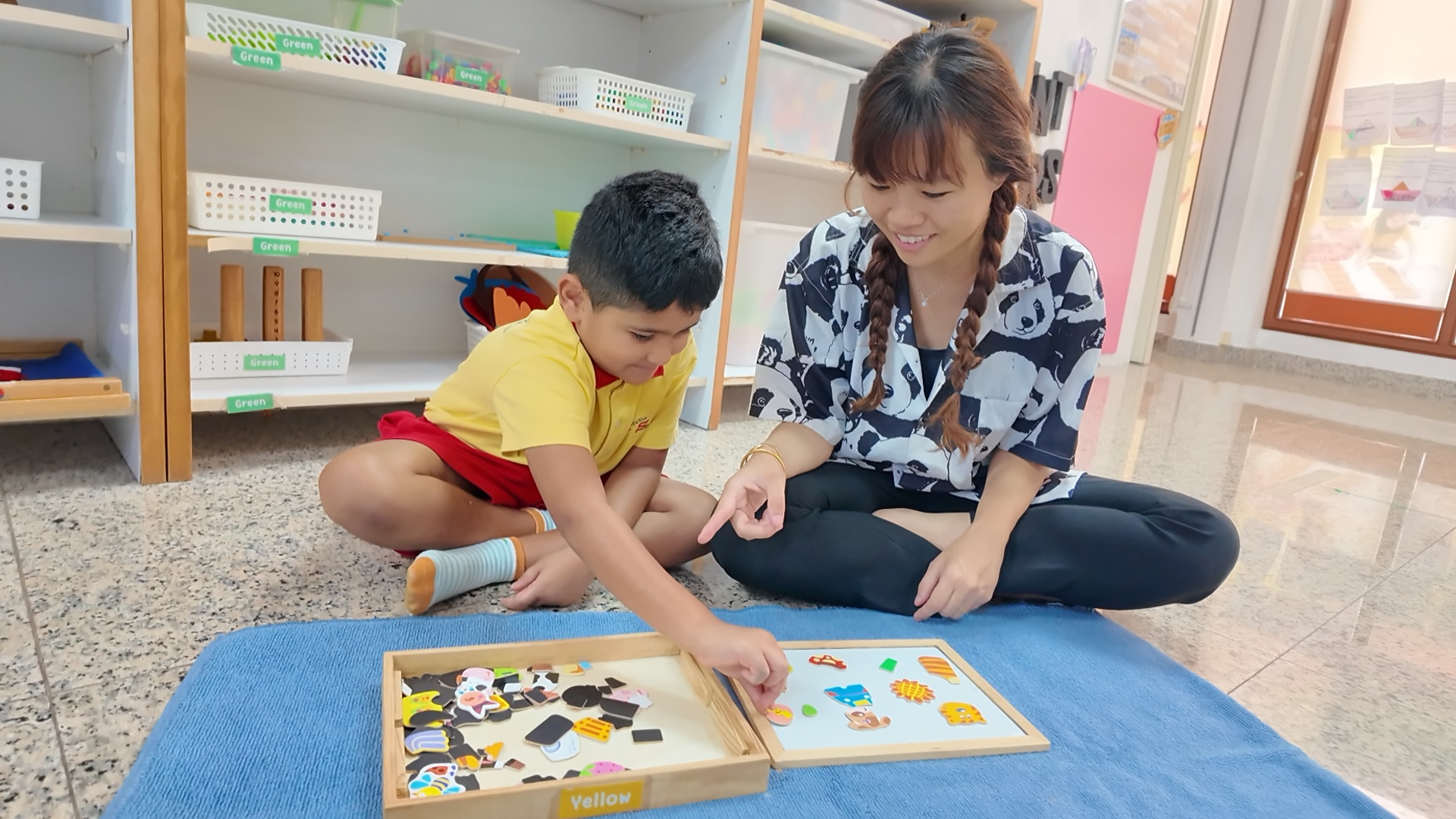 LittleSparks teacher guiding a child with a Montessori picture-matching puzzle