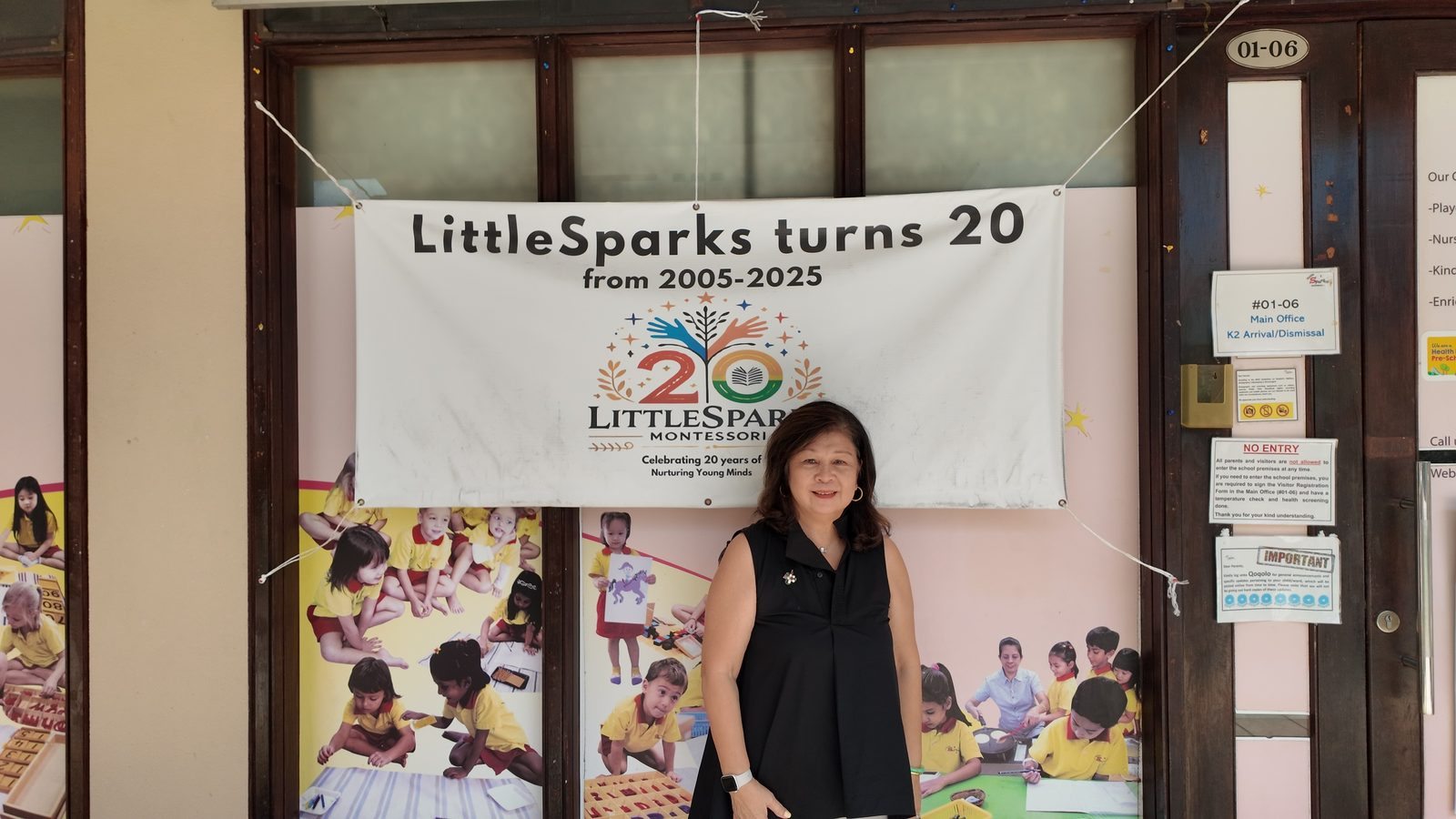 Gloria, our director, by the 20th anniversary banner