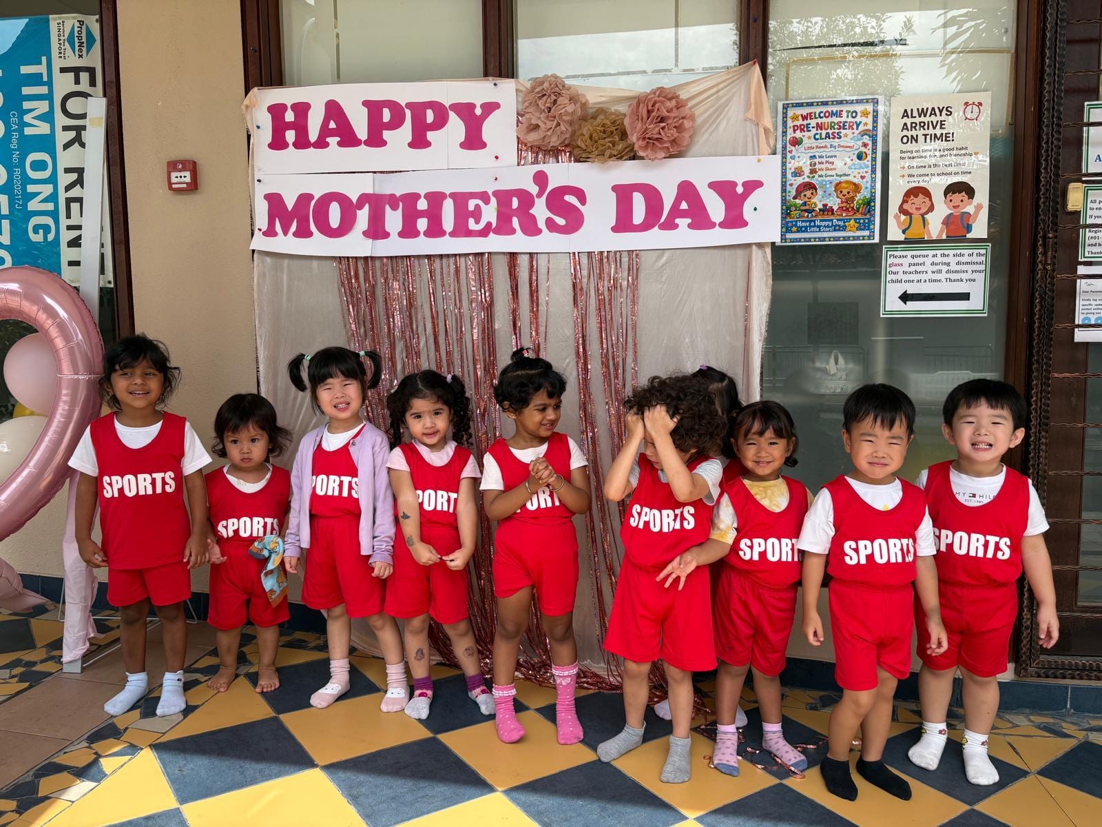 Children under a Happy Mother's Day classroom banner