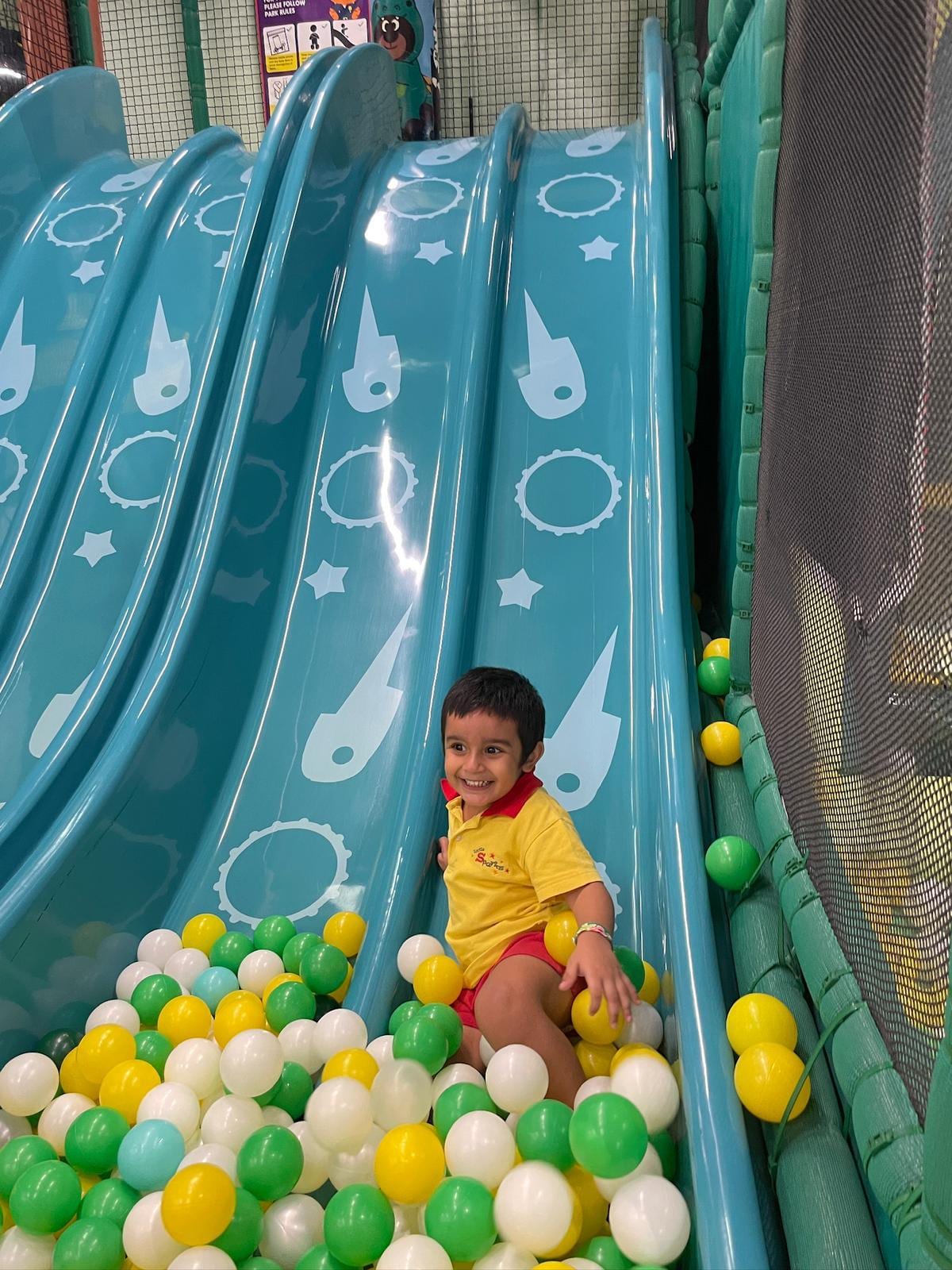 Child playing in the ball pit by the slide