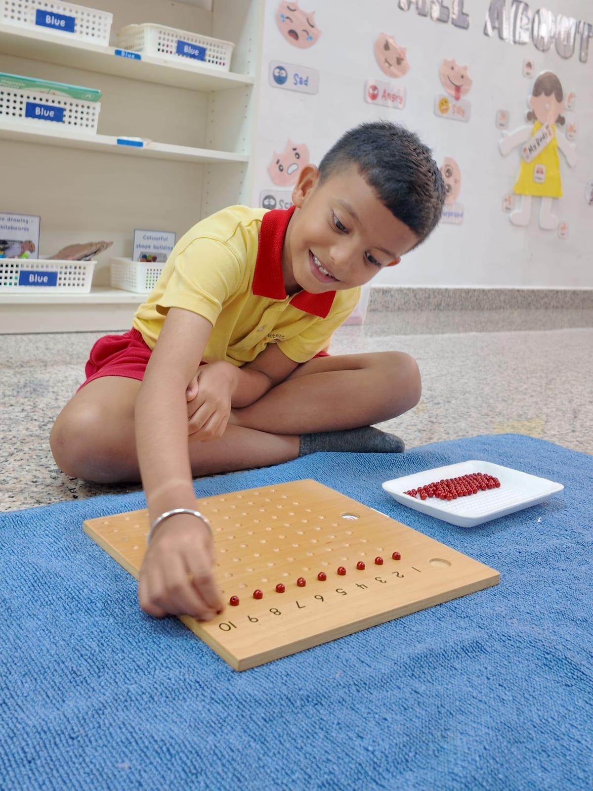 A child working with the Montessori number board and counting beads