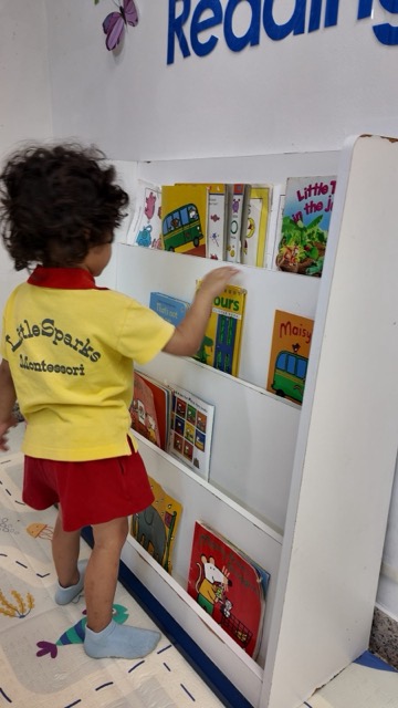 A child exploring books at the reading corner